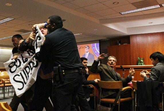Security removes radical activist, Kevin Zeese, from an FCC open meeting in 2014 (Popular Resistance)