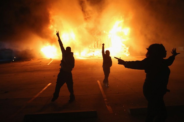 FERGUSON, MO - NOVEMBER 24: Demonstrators celebrate as a business burns after it was set on fire during rioting following the grand jury announcement in the Michael Brown case on November 24, 2014 in Ferguson, Missouri. Ferguson has been struggling to return to normal after Brown, an 18-year-old black man, was killed by Darren Wilson, a white Ferguson police officer, on August 9. His death has sparked months of sometimes violent protests in Ferguson. A grand jury today declined to indict officer Wilson. (Photo by Scott Olson/Getty Images)