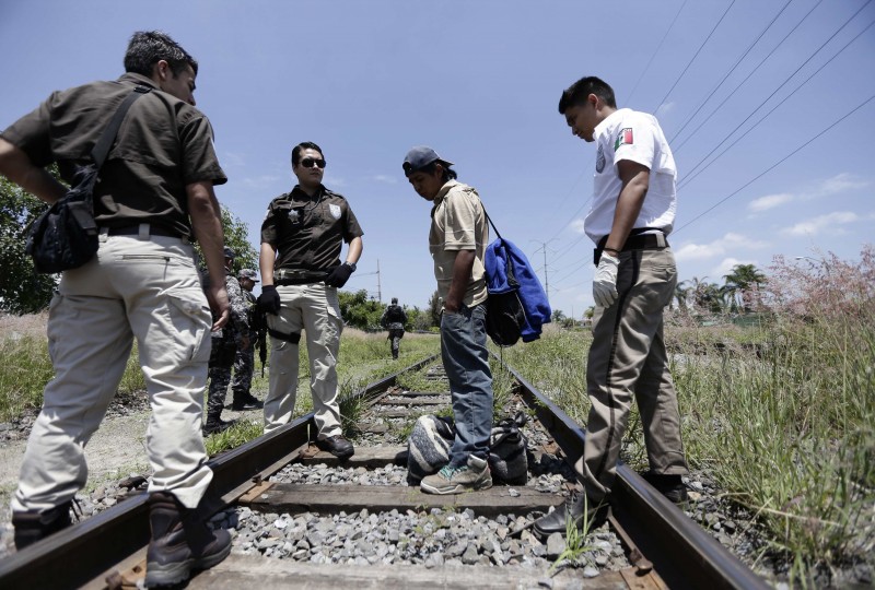 Mexican immigration officers talk with a man whom they suspect to be an illegal immigrant during a search operation in Zapopan near Guadalajara, Mexico July 29, 2014. REUTERS/Alejandro Acosta/File Photo