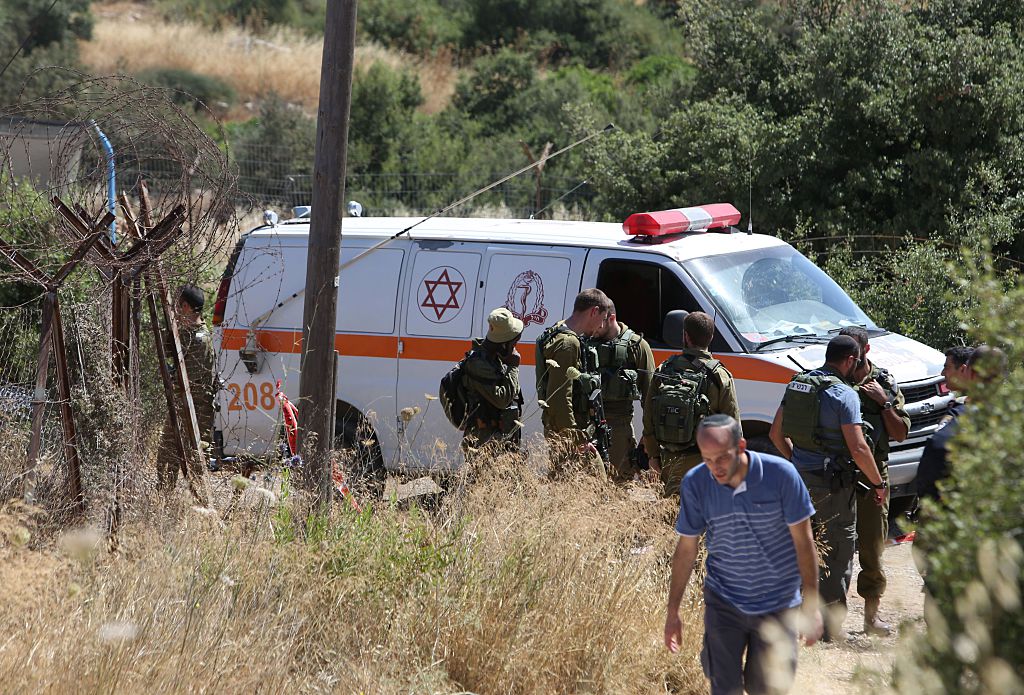 An Israeli ambulance and soldiers are seen outside a house in the Jewish settlement of Kiryat Arba in the occupied West Bank where a 13-year-old Israeli girl was fatally stabbed on June 30 (Getty Images)