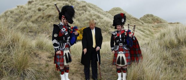 U.S. property mogul Donald Trump (C) poses next to bagpipers during a media event on the sand dunes of the Menie estate, the site for Trump's proposed golf resort, near Aberdeen, north east Scotland May 27, 2010. REUTERS/David Moir (BRITAIN POLITICS - Tags: SPORT GOLF BUSINESS) - RTR2EF9L