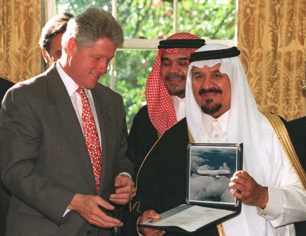 WASHINGTON, DC - OCTOBER 26: Saudi Defense and Aviation Minister Prince Sultan Bin Abdul Aziz(R) presents airplane contracts with US companies worth 6 billion USD to US President Bill Clinton(L) 26 October in the Oval Office at the White House in Washington DC. Prince Bandar(C) stands behind Clinton and Aziz. AFP PHOTO (Photo credit should read RICHARD ELLIS/AFP/Getty Images)
