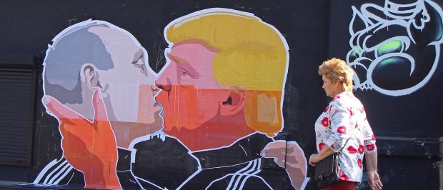 A woman walks past a mural on a restaurant wall depicting US Presidential hopeful Donald Trump and Russian President Vladimir Putin greeting each other with a kiss in the Lithuanian capital Vilnius on May 13, 2016. (PETRAS MALUKAS/AFP/Getty Images)