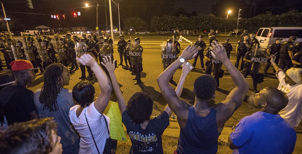 Protesters in Baton Rouge, LA shout "Hands up, don't shoot" as law enforcement stand watch (Getty Images)