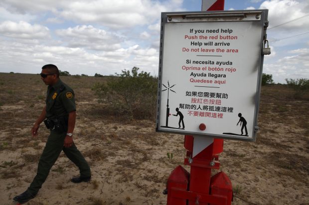 A U.S. Border Patrol agent walks past a rescue beacon near Falfurrias, Texas March 29, 2013. Brooks County has become an epicentre for illegal immigrant deaths in Texas. In 2012, sheriff's deputies found 129 bodies there, six times the number recorded in 2010. Most of those who died succumbed to the punishing heat and rough terrain that comprise the ranch lands of south Texas. Many migrants spend a few days in a "stash house", such as the Casa del Migrante, in Reynosa, Mexico, and many are ignorant of the treacherous journey ahead. Picture taken March 29, 2013. REUTERS/Eric Thayer 
