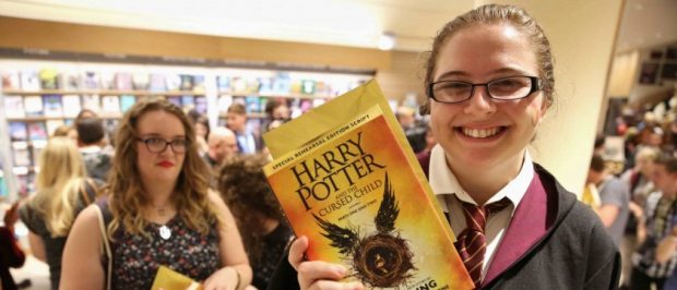 A woman holds copies of the book of the play of Harry Potter and the Cursed Child parts One and Two at a bookstore in London, Britain July 31, 2016. REUTERS/Neil Hall/File Photo