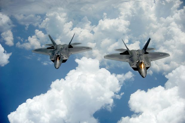 A pair of F-22 Raptors pulls away and flies behind a KC-135 Stratotanker after receiving fuel off of the East Coast on July 10, 2012. The 1st Fighter Wing at Joint Base Langley-Eustis, Va., received their first two Raptors in January 2005 and the wingÕs 27th Fighter Squadron was designated as fully operational in December 2005. The Raptors belong to the 27th FS and the KC-135 belongs to the 756th Air Refueling Squadron at Joint Base Andrews Naval Air Facility, Md. (U.S. Air Force photo by Master Sgt. Jeremy Lock)