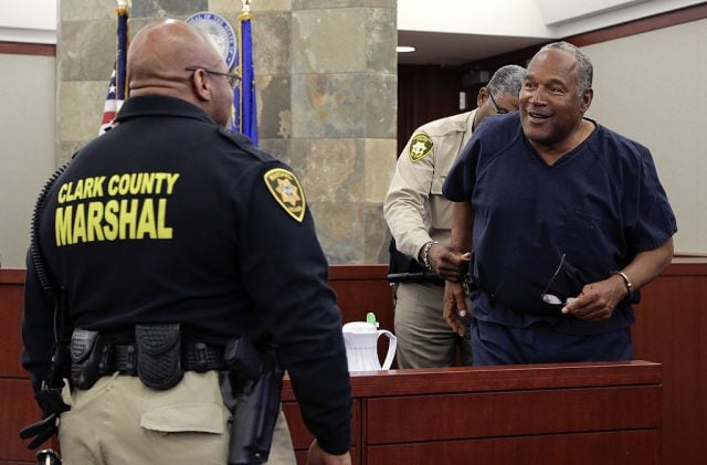 LAS VEGAS, NV - MAY 15: O.J. Simpson (R) is handcuffed and escorted away from the witness stand during a break in an evidentiary hearing in Clark County District Court May 15, 2013 in Las Vegas, Nevada. Simpson, who is currently serving a nine to 33-year sentence in state prison as a result of his October 2008 conviction for armed robbery and kidnapping charges, is using a writ of habeas corpus to seek a new trial, claiming he had such bad representation that his conviction should be reversed. (Photo by Julie Jacobson - Pool/Getty Images)