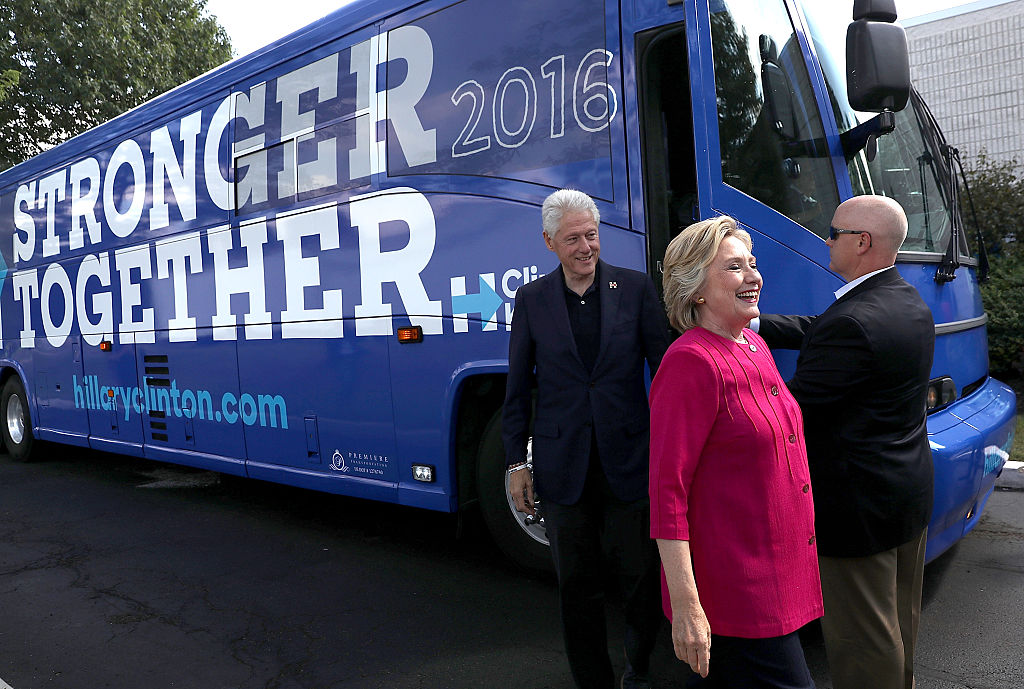 Hillary Clinton and her husband former U.S. President Bill Clinton walk off of their campaign bus before a rally in Hatfield, Pennsylvania (Getty Images)