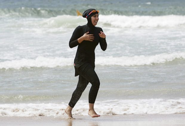 Twenty-year-old trainee volunteer surf life saver Mecca Laalaa runs along North Cronulla Beach in Sydney during her Bronze medallion competency test January 13, 2007. Specifically designed for Muslim women, Laalaa's body-covering swimming costume has been named the "burkini" by its Sydney based designer Aheda Zanetti. REUTERS/Tim Wimborne (AUSTRALIA)