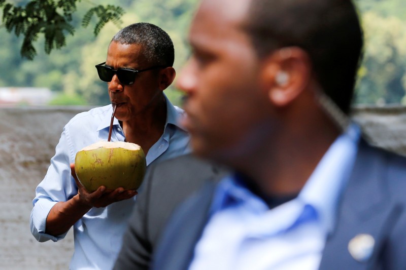 A Secret Service agent keeps watch as U.S. President Barack Obama drinks water of a fresh-cut coconut on a walk in Luang Prabang, Laos September 7, 2016. REUTERS/Jonathan Ernst