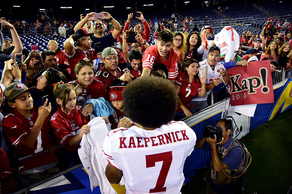 Colin Kaepernick signs autographs for fans after a game. (Photo by Harry How/Getty Images)