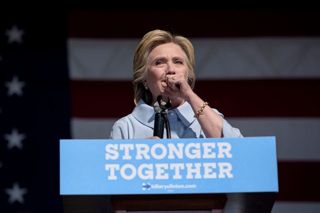 Democratic presidential nominee Hillary Clinton coughs during a Labor Day rally September 5, 2016 in Cleveland, Ohio. Hillary Clinton launched the home stretch of her US presidential bid aiming to solidify her advantages over rival Donald Trump, with both candidates converging on working-class Ohio as ground zero of their 2016 campaign battle
