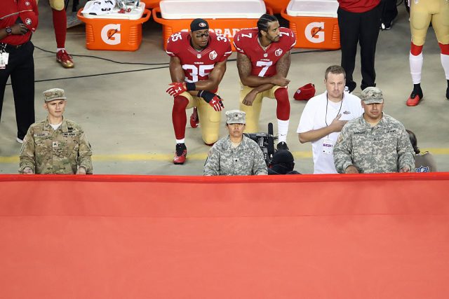 Colin Kaepernick and Eric Reid kneel in protest during the national anthem (Photo by Ezra Shaw/Getty Images)