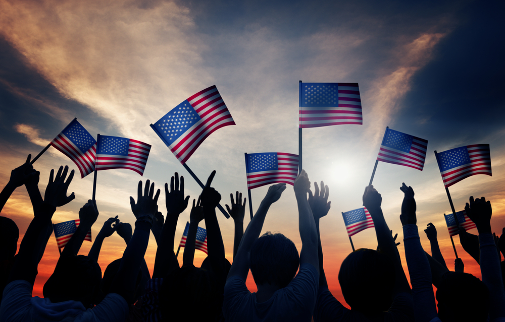 People hold American flags (Shutterstock)