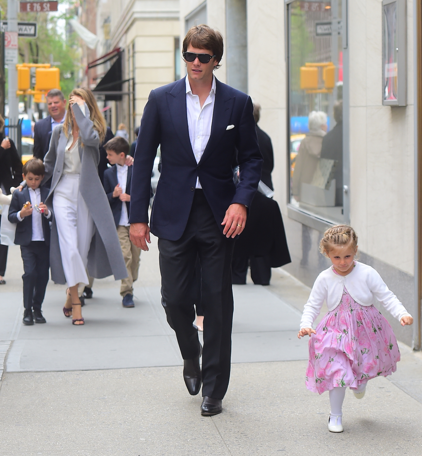 Tom follows his daughter Vivian down the sidewalk with the rest of the family close behind (Photo credit: Splash News)