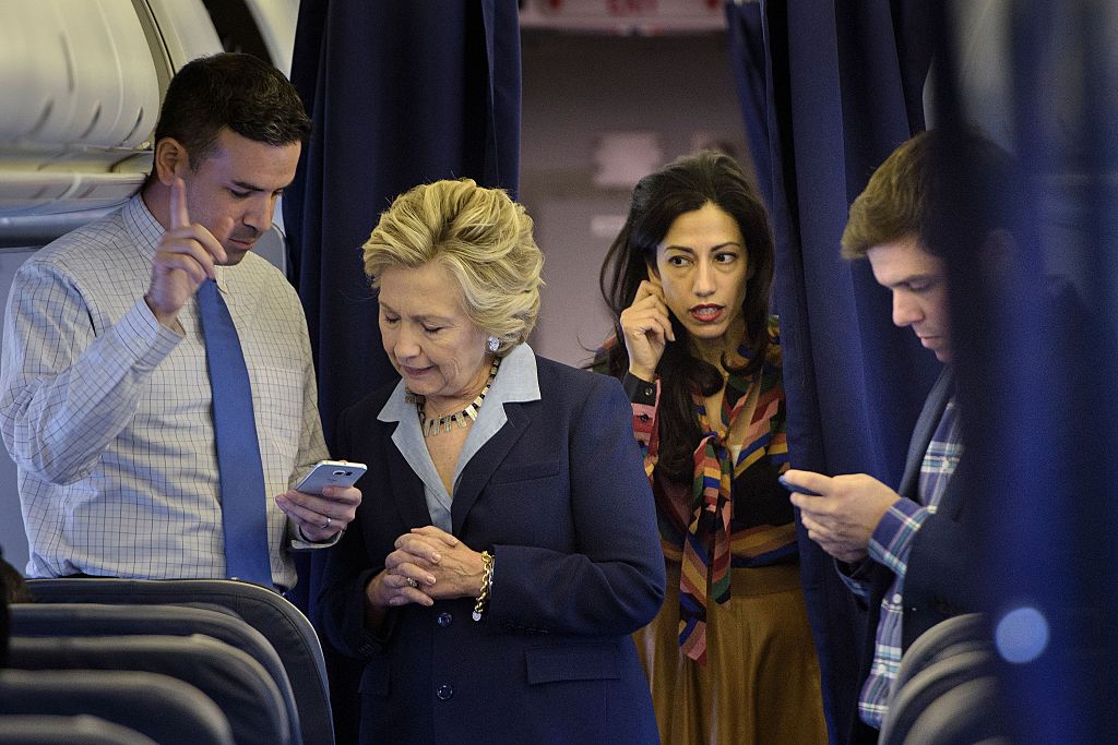Hillary Clinton looks at national press secretary Brian Fallon's smart phone while on her plane with aid Huma Abedin and traveling press secretary Nick Merrill Getty Images)