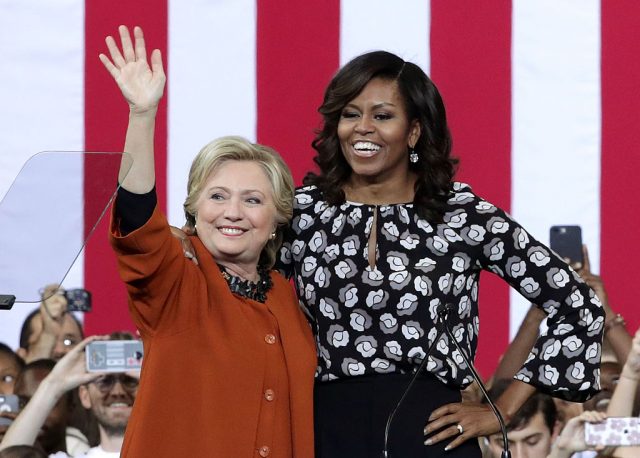 Democratic presidential candidate Hillary Clinton and first lady Michelle Obama greet supporters during a campaign event at the Lawrence Joel Veterans Memorial Coliseum October 27, 2016 in Winston-Salem, North Carolina. The first lady joined Clinton for the first time to campaign for the upcoming presidential election