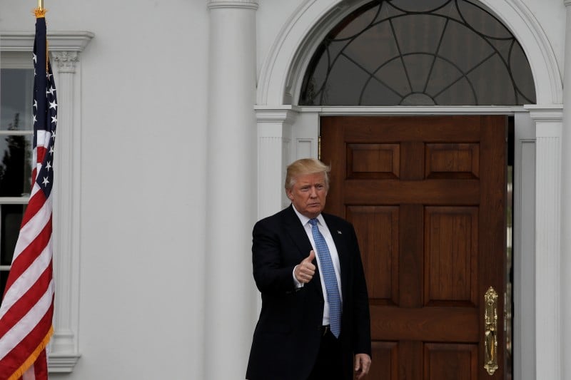 U.S. President-elect Donald Trump gestures from the front door at the main clubhouse at Trump National Golf Club in Bedminster, New Jersey, U.S., November 20, 2016. REUTERS/Mike Segar