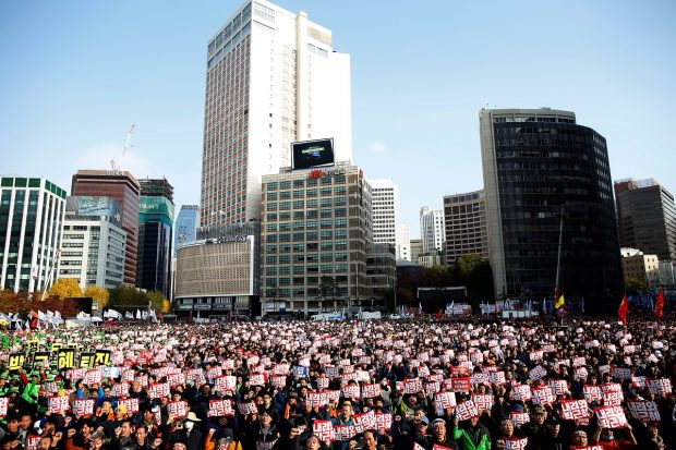 People chant slogans during a rally calling for President Park Geun-hye to step down in central Seoul, South Korea, November 12, 2016. The placards read, "Step down Park Geun-hye." REUTERS/Kim Hong-Ji