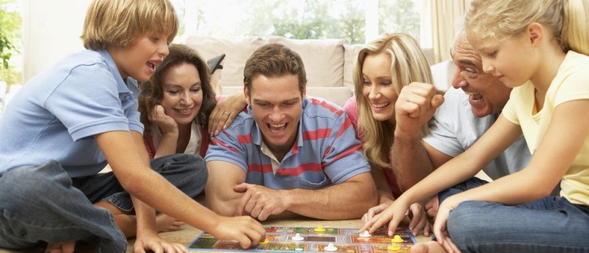 Family plays a board game (Photo via Shutterstock)
