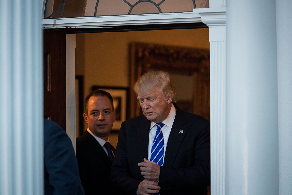 Reince Priebus looks on as Donald Trump prepares to greet Bob Woodson, president of the Center for Neighborhood Enterprise, at Trump International Golf Club (Getty Images)