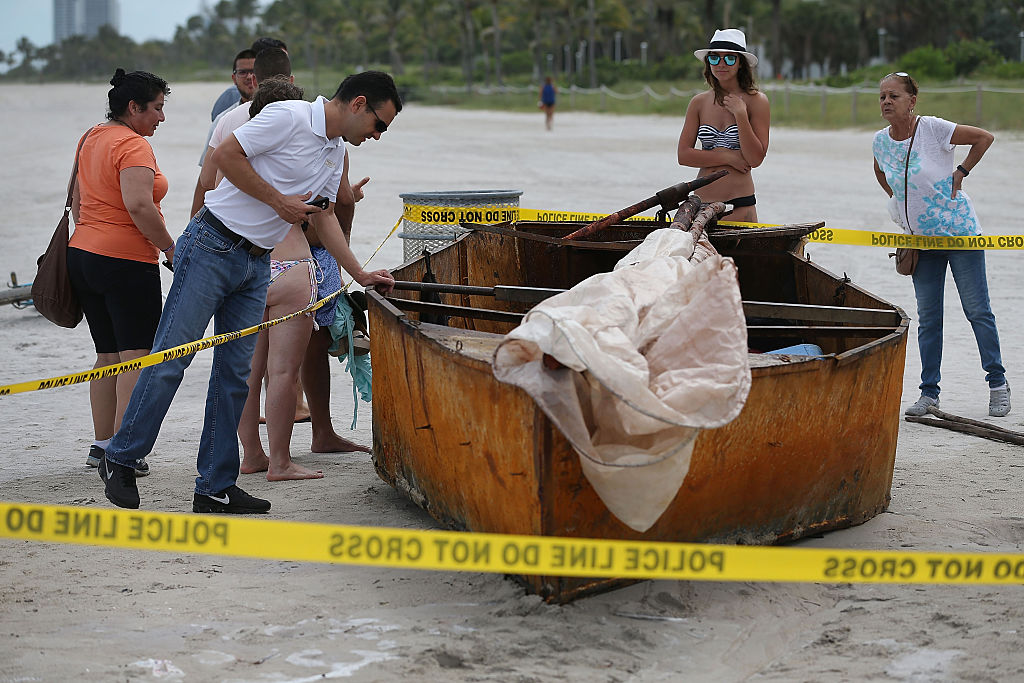 People look at a Cuban migrant boat that brought 12 people and a dog to the beach on September 15, 2015 in Miami Beach, Florida (Getty Images)