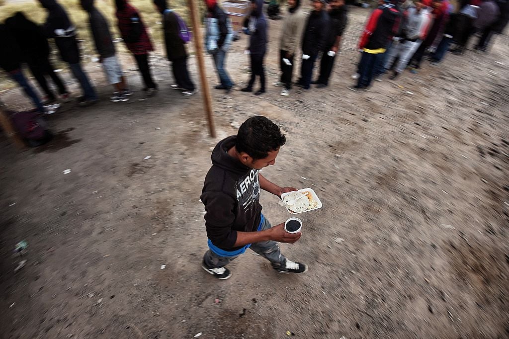 TOPSHOT - Migrants eat food donated by people from the Community Center for Migrant Assistance in the community of Caborca in Sonora state, Mexico, on January 13, 2017. Hundreds of Central American and Mexican migrants attempt to cross the US border daily. / AFP / ALFREDO ESTRELLA (Photo credit should read ALFREDO ESTRELLA/AFP/Getty Images)