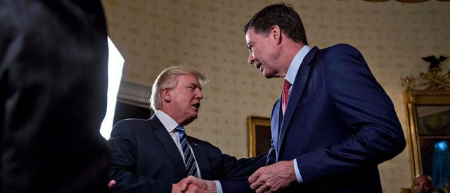 President Donald Trump shakes hands with James Comey, director of the Federal Bureau of Investigation, during an Inaugural Law Enforcement Officers and First Responders Reception in the Blue Room of the White House on January 22, 2017 in Washington, D.C. (Photo by Andrew Harrer-Pool/Getty Images)