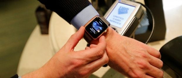 FILE PHOTO: A man uses an Apple Watch to demonstrate the mobile payment service Apple Pay at a cafe, October 3, 2016. Picture taken October 3, 2016. REUTERS/Maxim Zmeyev/File Photo