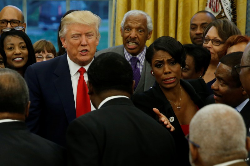 White House aide Omarosa Manigault (center R) directs traffic as U.S. President Donald Trump (center L) welcomes the leaders of dozens of historically black colleges and universities (HBCU) in the Oval Office at the White House in Washington, U.S. February 27, 2017. REUTERS/Jonathan Ernst