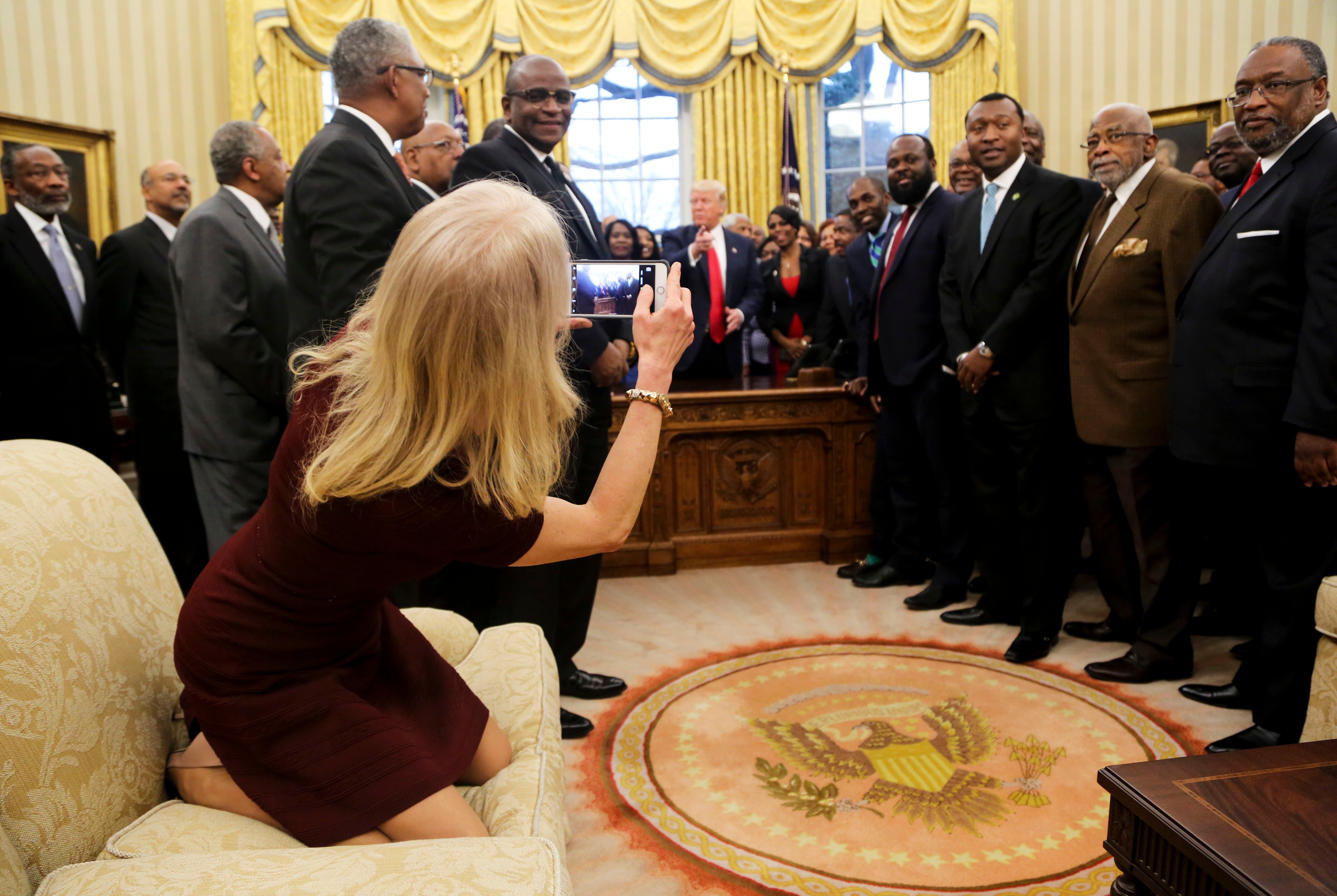 WASHINGTON, DC - FEBRUARY 27: Counselor to the President Kellyanne Conway takes a picture of U.S. President Donald Trump with members of the Historically Black Colleges and Universities in the Oval Office of the White House, on February 27, 2017 in Washington, DC. (Photo by Aude Guerrucci-Pool/Getty Images)