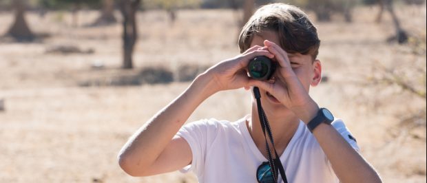 This boy uses his scope on a safari (Photo via Shutterstock)