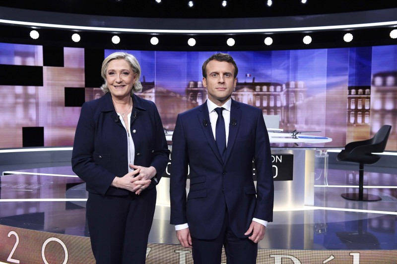 Candidates for the 2017 presidential election, Emmanuel Macron (R), head of the political movement En Marche !, or Onwards !, and Marine Le Pen, of the French National Front (FN) party, pose prior to the start of a live prime-time debate in the studios of French television station France 2, and French private station TF1 in La Plaine-Saint-Denis, near Paris, France, May 3, 2017. REUTERS/Eric Feferberg/Pool