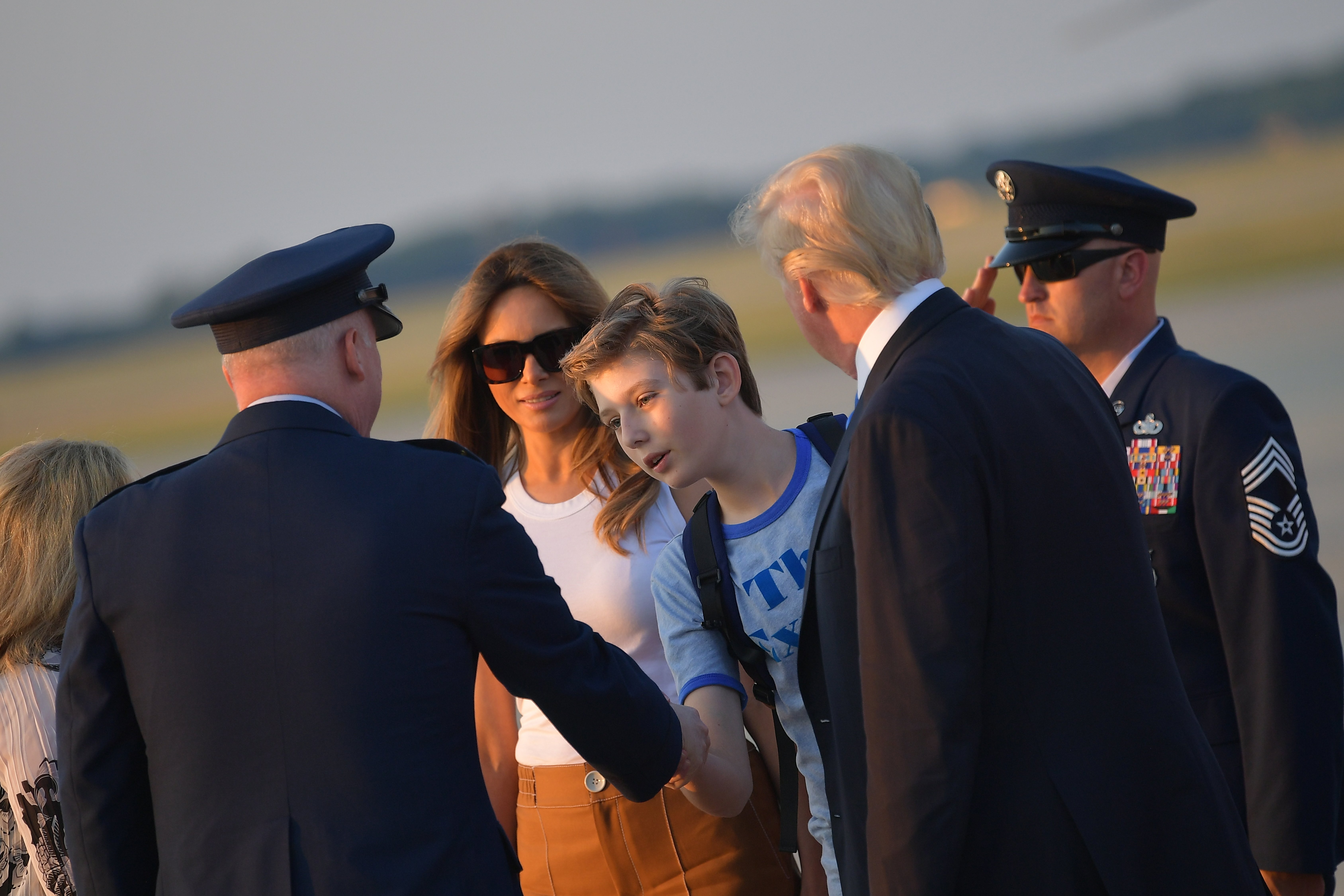 First Lady Melania Trump (2L) and US President Donald Trump (2R) watch as their son Barron Trump shakes hands with Col Al Smith who greeted them upon arrival at Andrews Air Force Base in Maryland on June 11, 2017. Trump is returning to Washington, DC after spending the weekend at this Bedminster, New Jersey golf club. MANDEL NGAN/AFP/Getty Images
