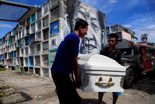 Graveyard workers carry the coffin of Eddie Languido, 56, victim of a summary execution by unknown assailants related to the drug war, during his funeral, attended by his son and friends, at the Navotas cemetery, north of Metro Manila, Philippines January 31, 2017. REUTERS/Romeo Ranoco