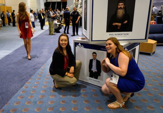 Women pose for a photo with photos of speakers, including Ben Shapiro (lower) and Phil Robertson, at the Western Conservative Summit in Denver July 1, 2016. REUTERS/Rick Wilking