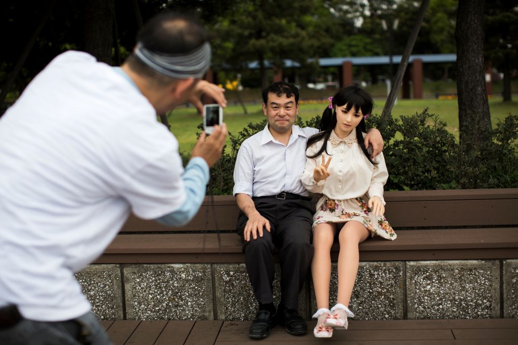 In this picture taken on May 9, 2017, a man takes pictures of physiotherapist Masayuki Ozaki and his silicone sex doll Mayu in Tokyo Bay. (Photo: BEHROUZ MEHRI/AFP/Getty Images)