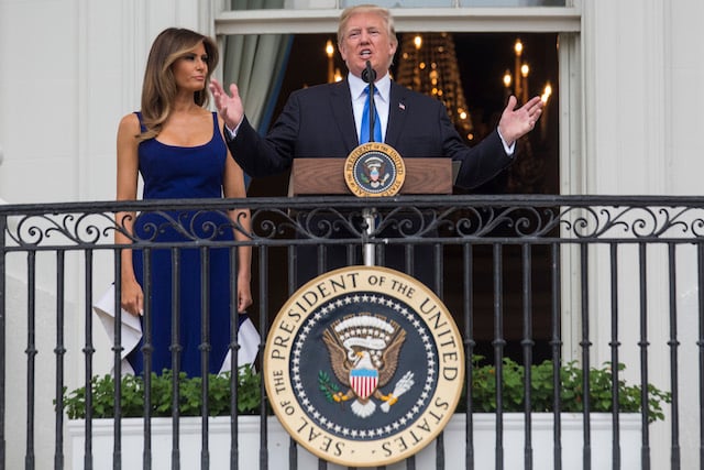 WASHINGTON, DC - JULY 4: U.S. President Donald Trump delivers remarks as first lady Melania Trump looks on from the Truman Balcony on July 4, 2017 in Washington, DC. The president was hosting a picnic for military families for the July 4 holiday. (Photo by Zach Gibson/Getty Images)