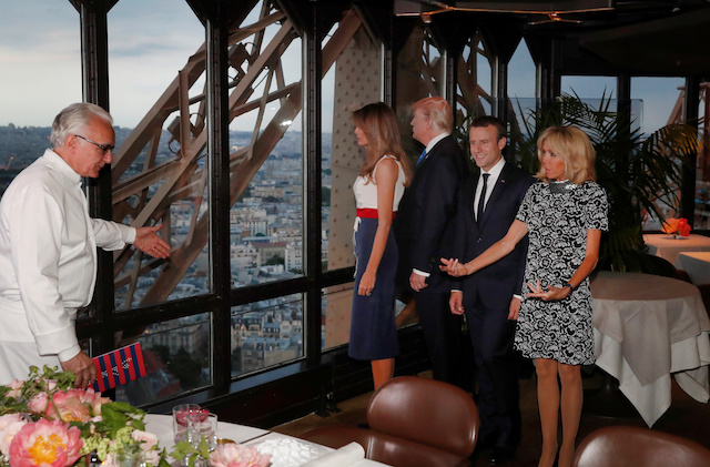 French chef Alain Ducasse (L) gestures as, from R, Brigitte Macron, wife of French President Emmanuel Macron, U.S. President Donald Trump and First lady Melania Trump gather at the Jules Verne restaurant before a private dinner at the Eiffel Tower in Paris, France, July 13, 2107. REUTERS/Yves Herman - RTX3BD3G