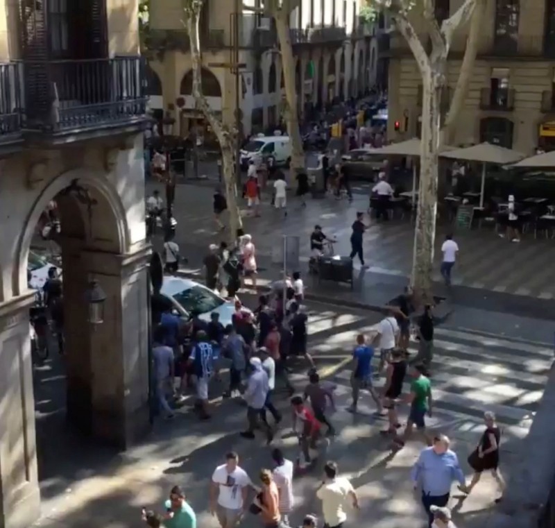 People move from the scene after a van crashed into pedestrians near the Las Ramblas avenue in central Barcelona, Spain August 17, 2017, in this still image from a video obtained from social media. Courtesy of McKenzie Tavoda/via REUTERS 