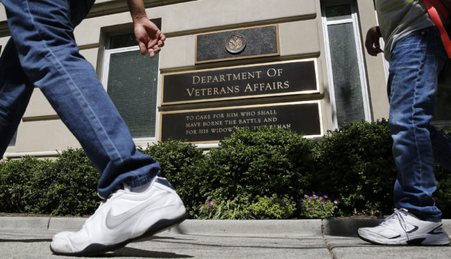 The sign in the front of the headquarters building at the Department of Veteran Affairs is seen as people walk past in Washington, May 23, 2014. REUTERS/Larry Downing