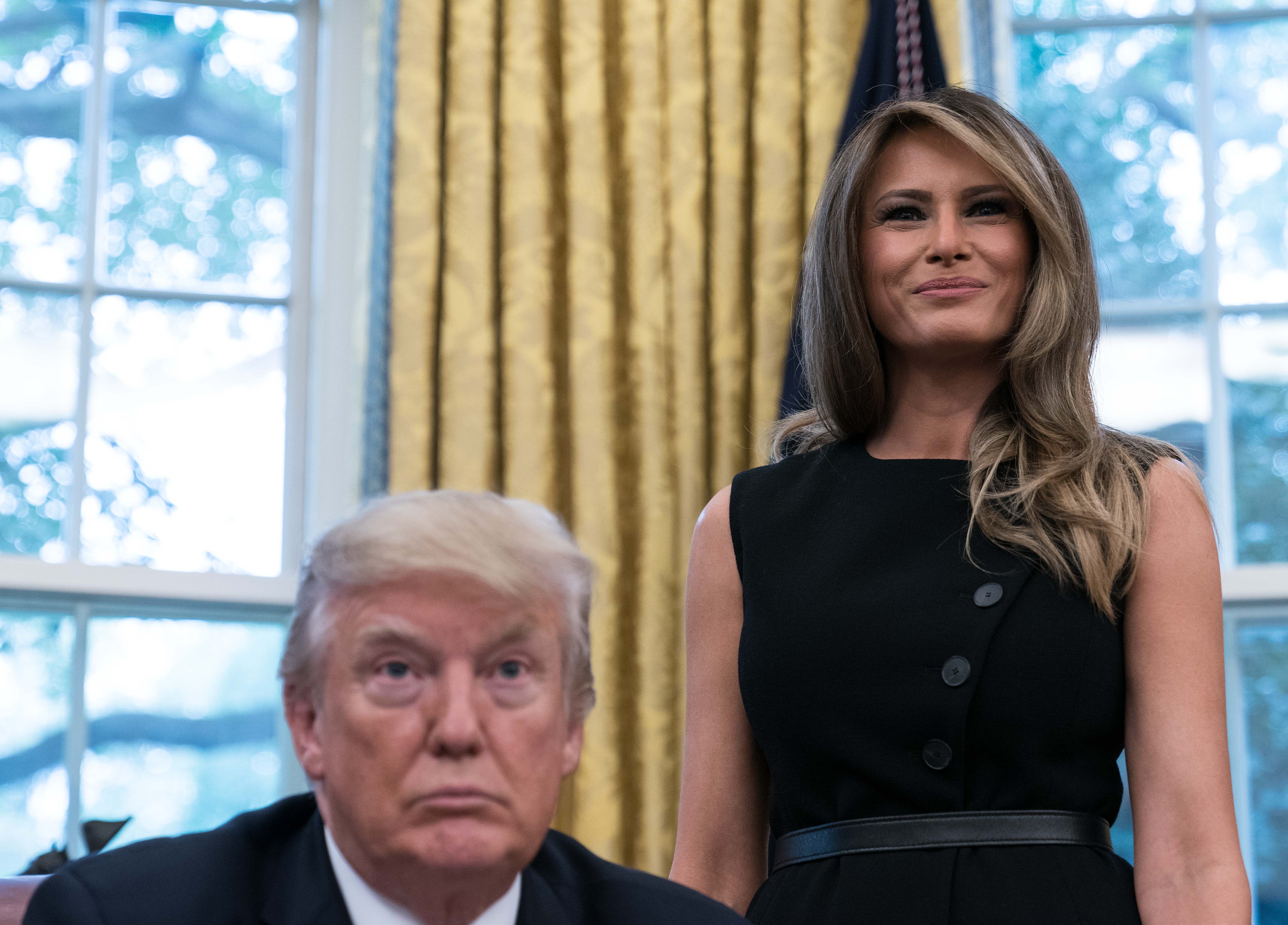 US First Lady Melania Trump smiles after speaking as President Donald Trump looks on following an update from disaster relief organizations on Hurricane Harvey recovery efforts in the Oval Office at the White House in Washington, DC, on September 1, 2017. / AFP PHOTO / NICHOLAS KAMM (Photo credit should read NICHOLAS KAMM/AFP/Getty Images)