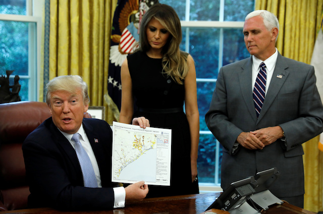 U.S. first lady Melania Trump and Vice President Mike Pence stand by U.S. President Donald Trump as he holds up FEMA map of damage assessment in Texas caused by Hurricane Harvey at the White House in Washington, U.S., September 1, 2017. REUTERS/Kevin Lamarque - RC157158EAE0