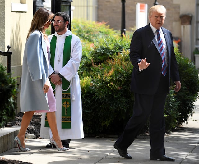 President Donald Trump waves to the press, as he departs St. John's Episcopal Church and Assistant Rector D. Andrew Olivo, (C), with First Lady Melania Trump after they attended services for a national "Day of Prayer", for victims of the Hurricane Harvey flooding in Texas, in Washington, U.S., September 3, 2017. REUTERS/Mike Theiler - RC160CB77370