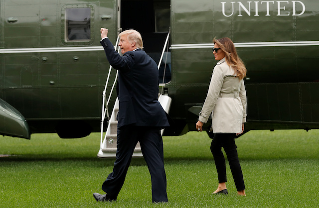 U.S. President Donald Trump pumps his fist toward well-wishers, as he and First Lady Melania Trump depart the White House in Washington, U.S., October 13, 2017. REUTERS/Kevin Lamarque