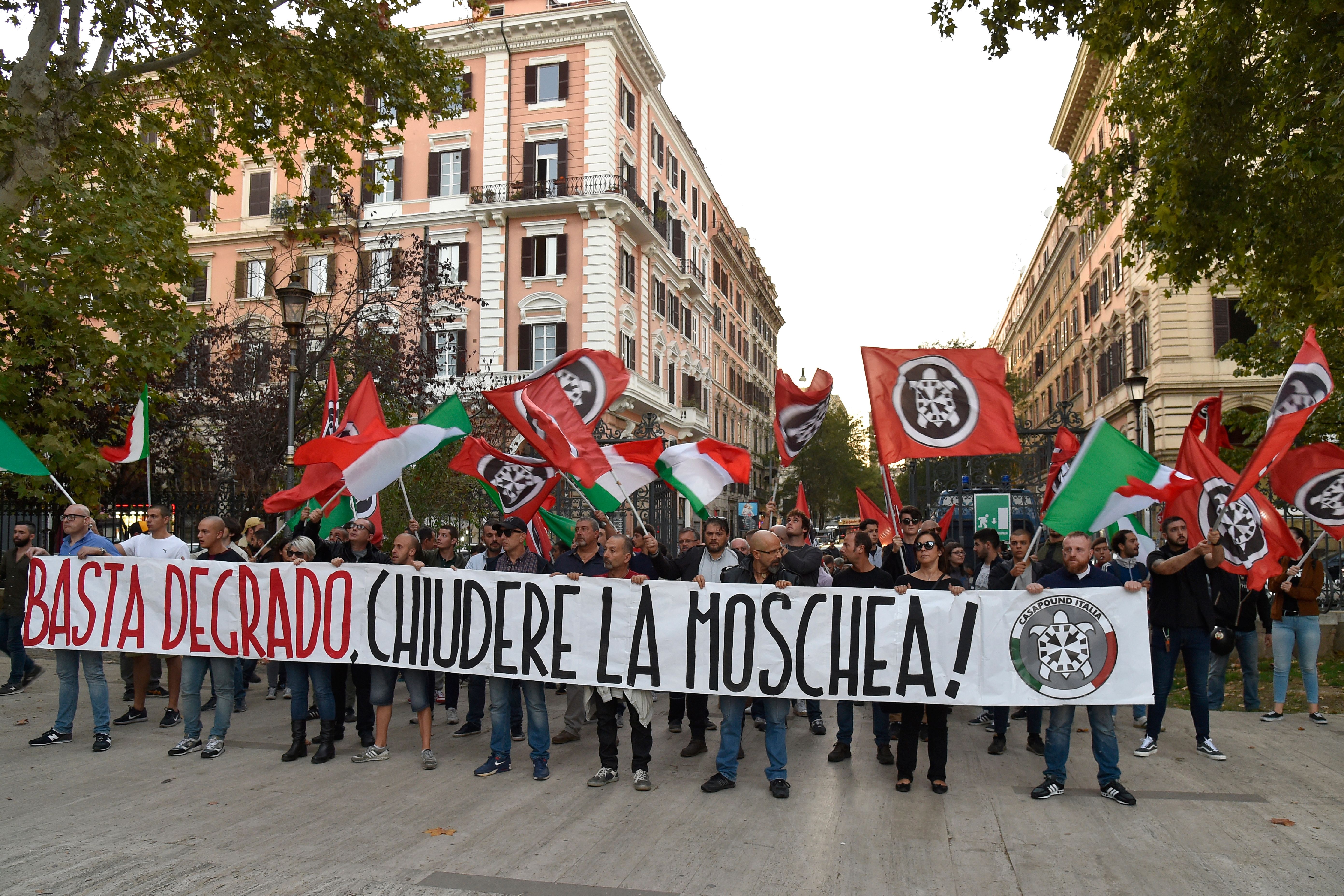 Supporters of Italian far-right movement CasaPound march behind a banner reading "Enough deterioration, Close the Mosque" during a protest against a mosque situated in Via San Vito on October 4, 2017 in the Esquilino district of Rome. / AFP PHOTO / Andreas SOLARO (Photo credit should read ANDREAS SOLARO/AFP/Getty Images)