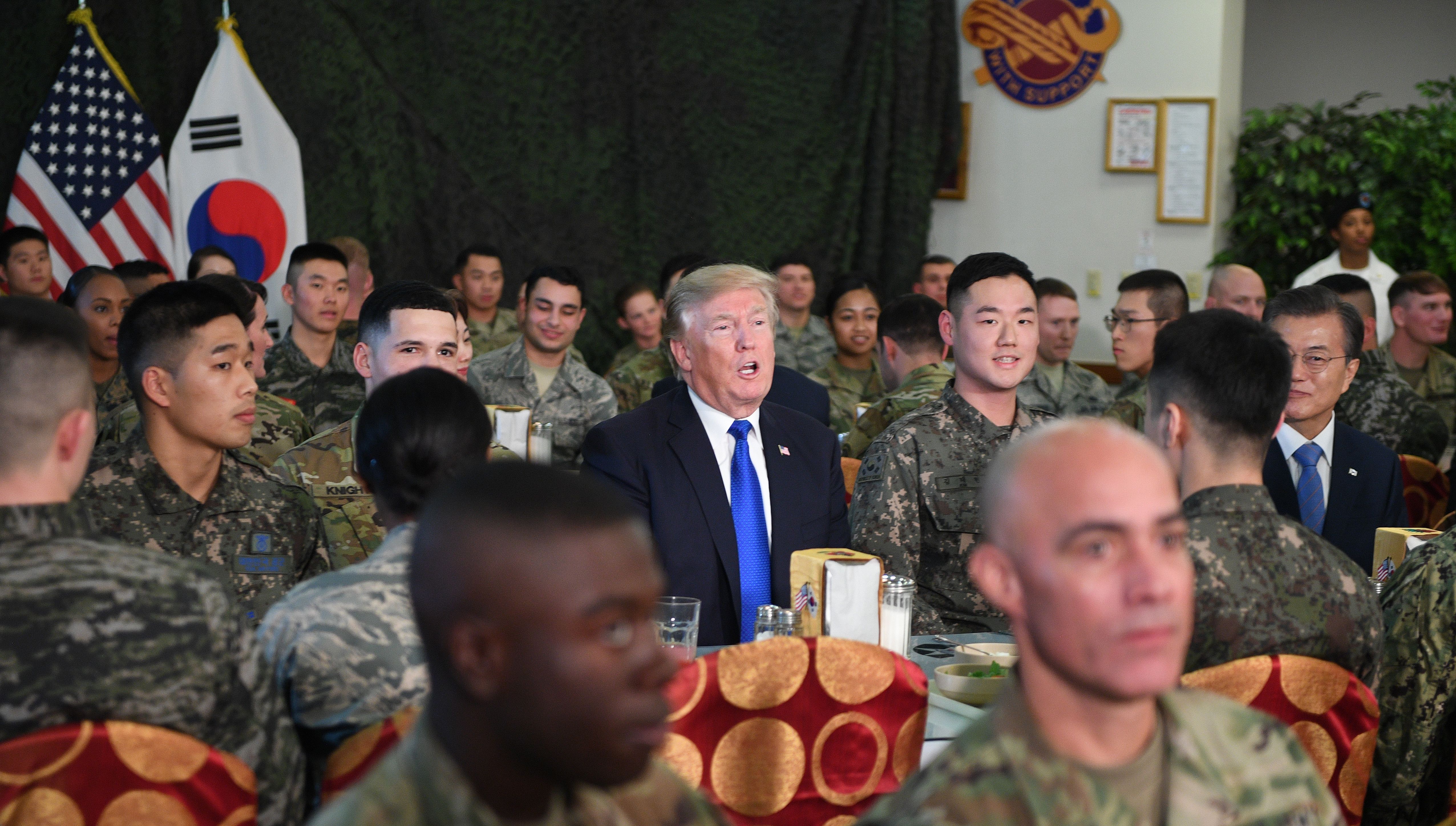 US President Donald Trump (C) talks to military personnel while South Korean President Moon Jae-In (R) looks on at Camp Humphreys in Pyeongtaek, south of Seoul on November 7, 2017. Trump's marathon Asia tour moves to South Korea, another key ally in the struggle with nuclear-armed North Korea, but one with deep reservations about the US president's strategy for dealing with the crisis. JIM WATSON/AFP/Getty Images