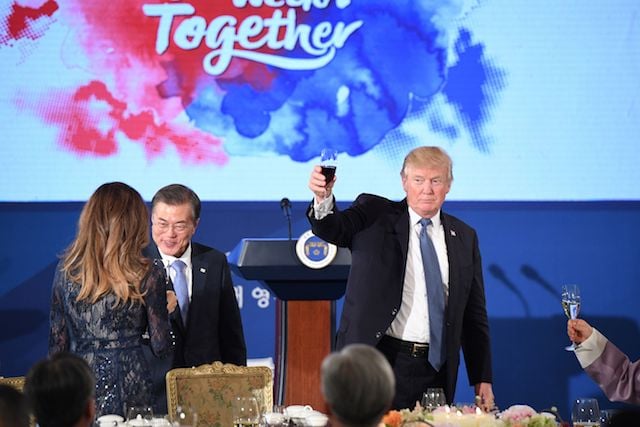 US President Donald Trump (R) holds a glass as South Korea's President Moon Jae-In (C) talks to First Lady Melania Trump during a state dinner at the presidential Blue House in Seoul on November 7, 2017. North Korea poses a worldwide threat that requires worldwide action, President Donald Trump said in Seoul on November 7, but insisted "we are making a lot of progress" in reining in the rogue state. / AFP PHOTO / Jim WATSON (Photo credit should read JIM WATSON/AFP/Getty Images)