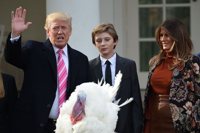 US President Donald Trump waves after he pardoned the turkey, Drumstick, as First Lady Melania Trump (R) and their son Barron look on during the turkey pardoning ceremony at the White House in Washington, DC on November 21, 2017. / AFP PHOTO / ANDREW CABALLERO-REYNOLDS (Photo credit should read ANDREW CABALLERO-REYNOLDS/AFP/Getty Images)